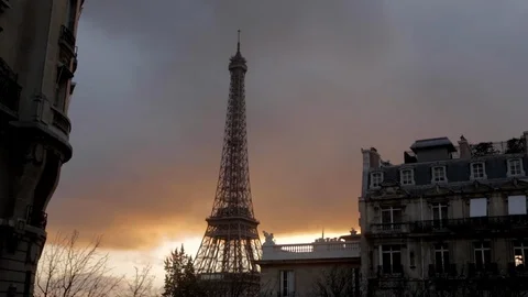 Eiffel tower in a cloudy orange sky with an old Parisian lamp post in the Stock Footage 110694744