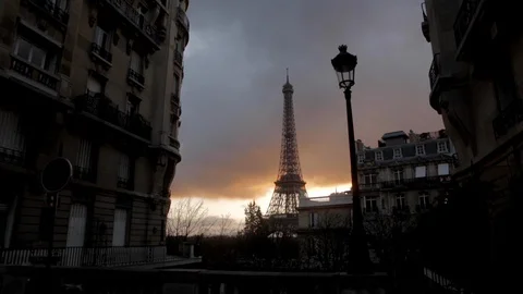 Eiffel tower in a cloudy orange sky with an old Parisian lamp post in the Stock Footage 110695038