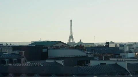 Eiffel tower emerging from parisian rooftops at dawn Stock Footage 310874827