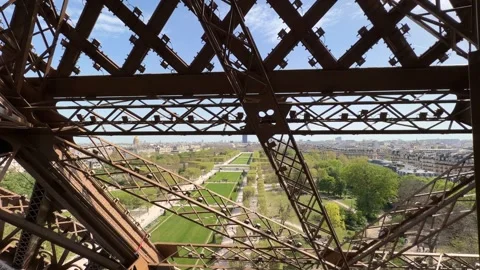 Eiffel Tower latticework framing Paris skyline and Champ de Mars Stock Footage 334133963