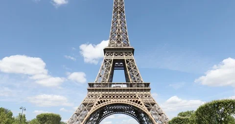 Eiffel Tower in Paris, tilt view, in a sunny day with green trees, blue sky Stock Footage 124579973