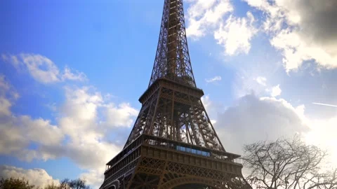Eiffel Tower in Paris view from below with sunlight blue sky and trees Stock Footage 317329617