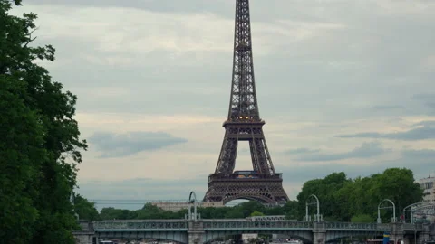 Eiffel Tower rises over Seine River bridge with cruise boats in Paris France Stock-Footage 337294373