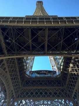 The Eiffel Tower seen from below, the tower soaring into a blue sky. Stock Photos