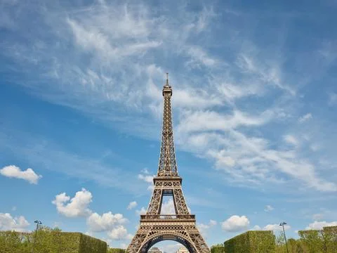 Eiffel tower standing tall under a cloudy blue sky in paris Stock Photos