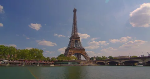 The Eiffel tower timelapse near river Seine in Paris. Ship and boats on river at Video stock 244461904