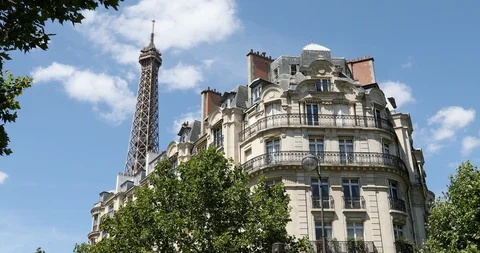 Eiffel Tower top and typical building in Paris with balcony, clear blue sky Stock Footage 124580533