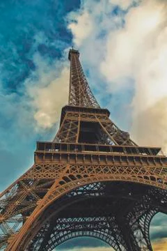 Eiffel tower view from the below angle with blue and cloudy sky, vintage filt Stock Photos