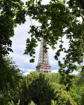 Eiffel Tower view through lush summer trees in Paris, France Stock Photos