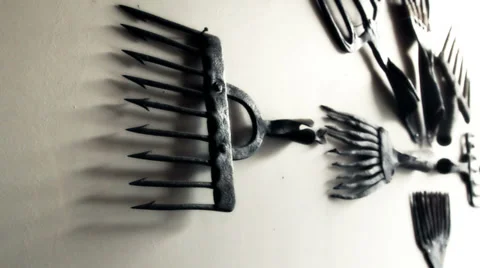 Eight black old fish rakes hanging on the wall Stock Footage 35118232