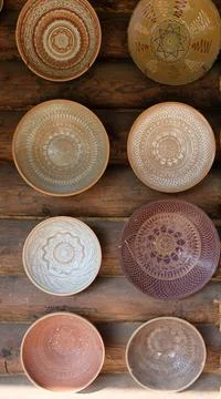 Eight ceramic plates with patterns on a wicker wall background Stock Photos