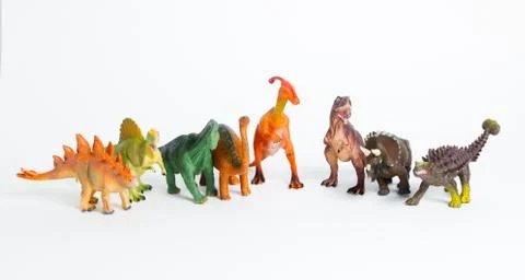 Eight colored different models of dinosaurs on white, children toys Stock Photos