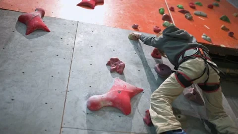 Eight year old boy climbs the climbing wall in the hall. Stock Footage 223495635