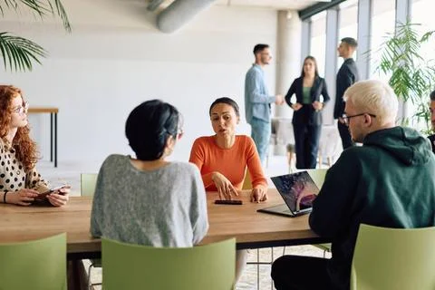 Ein bunt gemischtes Team von Geschäftsleuten, die an einem Konferenztisch .. 库存照片