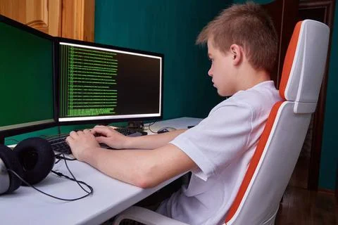 Ein junger Programmierer druckt den Programmcode auf dem Computerbildschir... Stock-Fotos