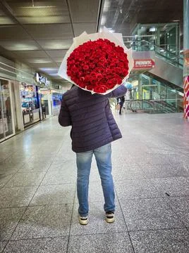  Ein Mann mit Rosen auf der Schulter steht im Ostbahnhof Berlin. 13.01.202... Stock Photos