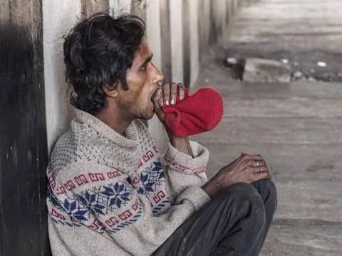 Ein obdachloser Inder schnüffelt an einer Socke - Strassenszene, Delhi, In.. Stock Photos