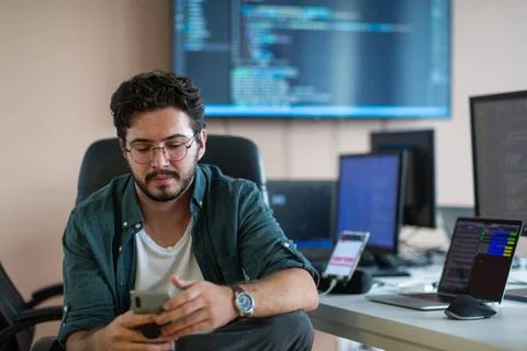 Ein Programmierer testet fleißig Smartphone-Anwendungen A programmer dilig.. Stock-Fotos