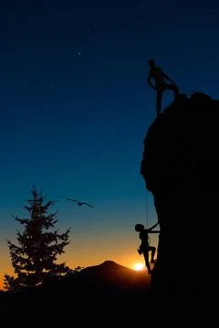 Ein Team von zwei Bergsteigern klettert in Seilschaft auf den Berg. Der er... Stock Photos