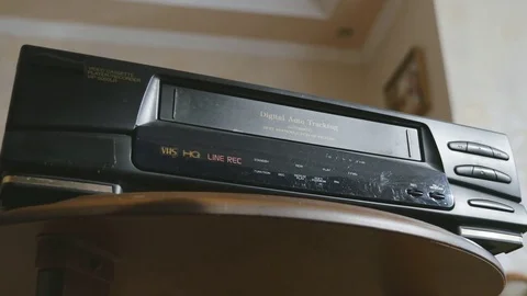 Ejecting the video cassette from the VCR or VHS. Black vintage video tape player Stock Footage 78118339