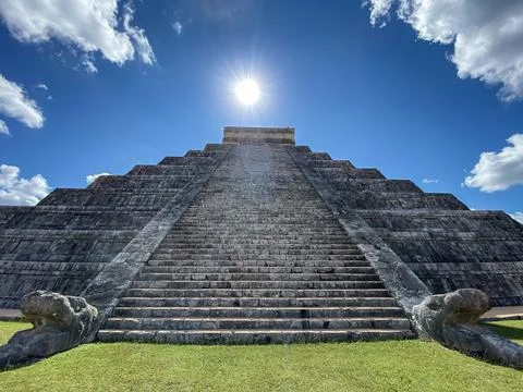 El Castillo at Chichen Itza with the sun and clouds above Stock Photos