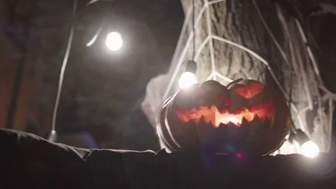 El kukui, pumpkin-headed on a background of light bulbs, evening street Stock Footage 115577937