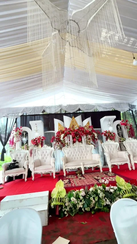 Elaborate wedding stage setup features ornate white seating under draped ceiling Video stock 328220157