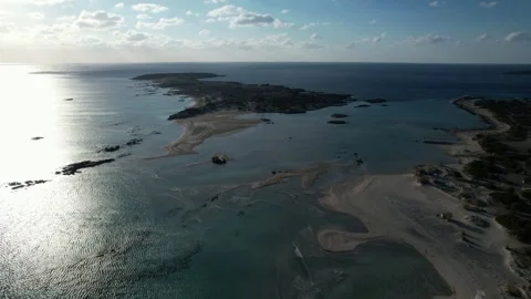 Elafonisi lagoon in backlight with sun glitter, aerial orbit Stock Footage 346723461