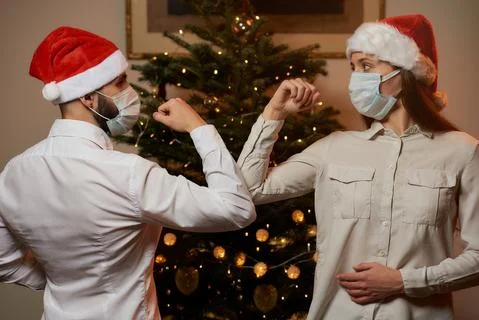 Elbow greeting to avoid the spread of COVID against background of Christmas t Stock Photos
