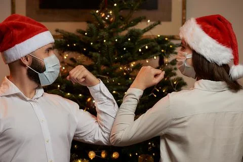 Elbow greeting to avoid the spread of COVID against background of Christmas t Stock Photos