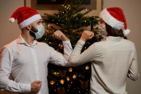 Elbow greeting to avoid the spread of COVID against background of Christmas t Stock Photos