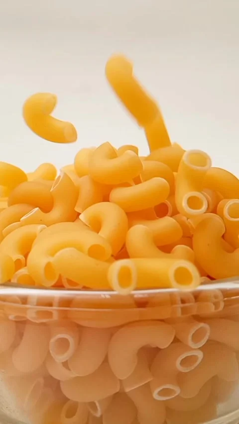 Elbow Macaroni Pasta Dropping in Glass Bowl on White Background, Uncooked Elbow  库存影片 334368235