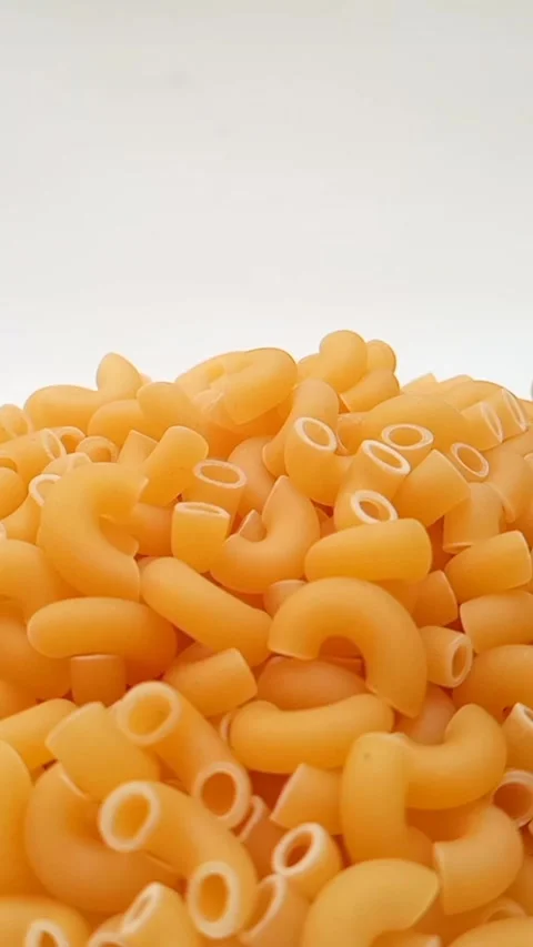 Elbow Macaroni Pasta Dropping on White Background, Uncooked Elbow Macaroni .. Видео 334368307