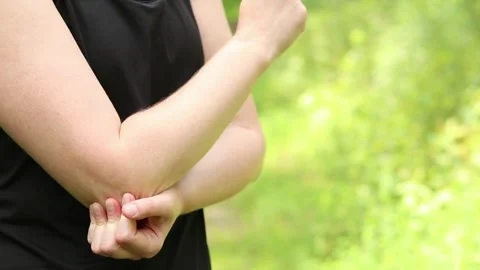 Elbow problem during training. Girl in sportswear massaging her bruised arm Stock Footage 311529271