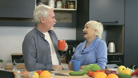 Elder couple drinking coffee (or tea) at the kitchen. Stock Footage 102216342