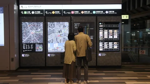 Elder couple looking at complex electronic train map at night. Tokyo, Japan. Vídeo Stock 247888668