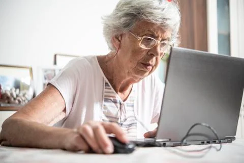 An elder lady using a laptop Stock Photos