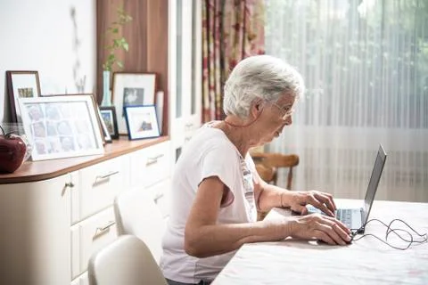 An elder lady using a laptop Stock Photos
