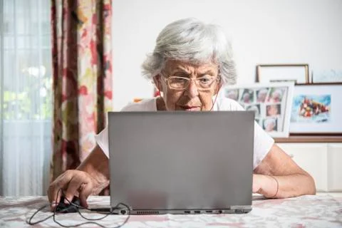 An elder lady using a laptop Stock Photos