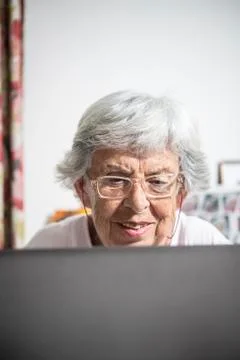 An elder lady using a laptop Stock Photos