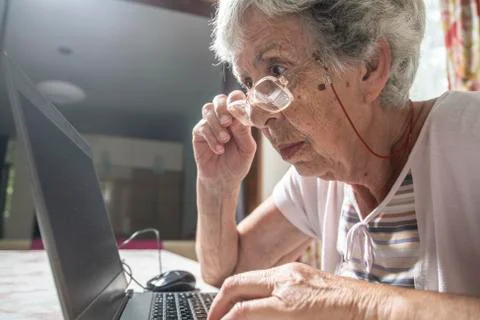 An elder lady using a laptop Stock Photos