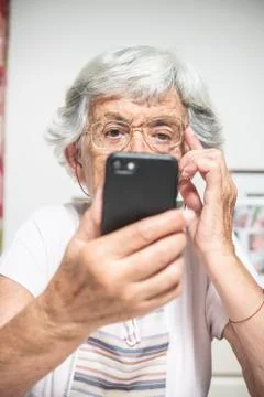 An elder lady using a smartphone Stock Photos