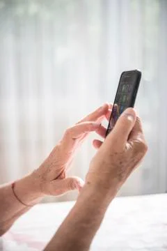 An elder lady using a smartphone Stock Photos