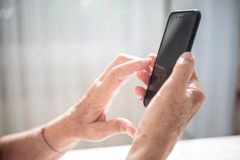 An elder lady using a smartphone Stock Photos
