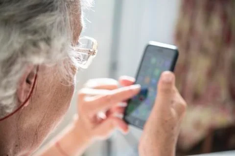 An elder lady using a smartphone Stock Photos