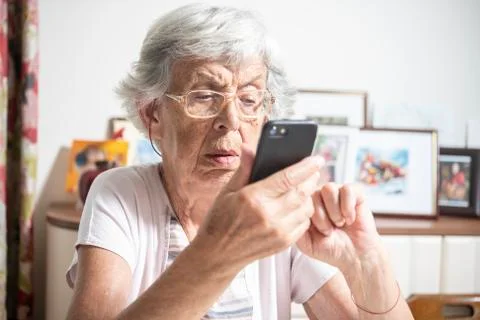 An elder lady using a smartphone Stock Photos