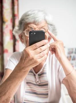 An elder lady using a smartphone Stock Photos