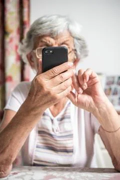 An elder lady using a smartphone Stock Photos