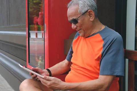 Elder man holding tablet. elderly senior male texting message, using app with Stock Photos