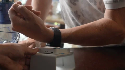 An elder man pay the bill with smart watch wirelessly on POS terminal using NFC Stock Footage 217375907